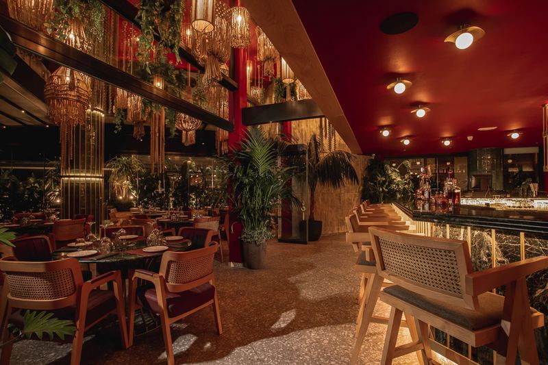 Al Hayat lounge with macramé chandeliers and warm red ceiling
