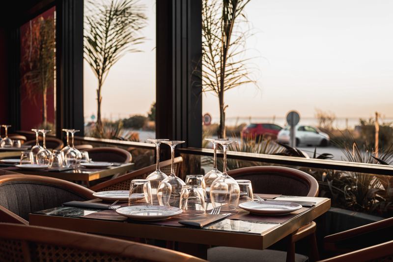 Outdoor terrace seating at sunset overlooking the marina